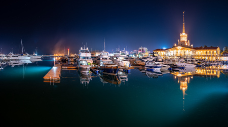 Marine Station of Sochi, illuminated with lights at night with reflection in water. Translation of the inscription above the central entrance to the building means Sochi .の写真素材