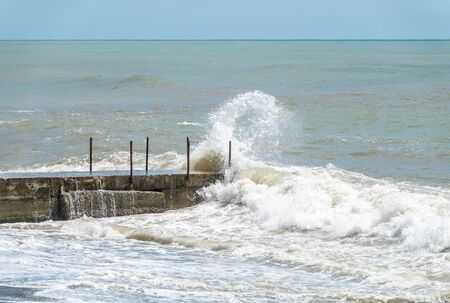Sea wave with spray during storm at Black sea in Sochi, Russia. Muddy sea waves with foam and spray.の写真素材