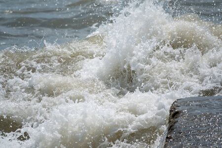 Sea wave with spray during storm at Black sea in Sochi, Russia. Muddy sea waves with foam and spray.の写真素材