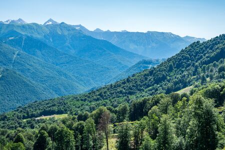 View over the Green Valley, surrounded by high mountains on a clear summer day. Krasnaya Polyana, Sochi, Russia.の写真素材