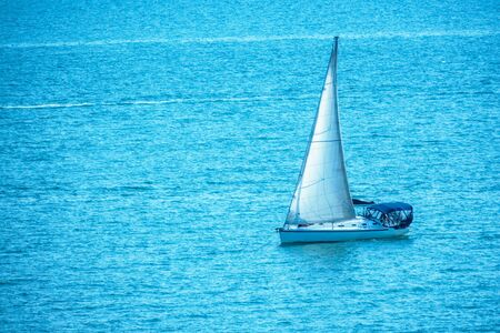 Sailing yacht in the blue calm sea. A yacht in peaceful waters.の写真素材