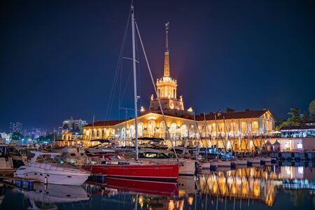 Marine Station of Sochi, illuminated with lights at night with reflection in water. Translation of the inscription above the central entrance to the building means Sochi .の写真素材