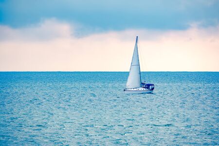 Sailing yacht in the blue calm sea. A yacht in peaceful waters.の写真素材