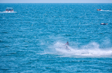 The jet ski swims quickly across the sea, picking up many waves and splashes. Fast ride on a jet ski...