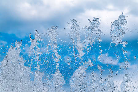 Splashes of water against the blue sky background. Fountain, a jet of water against the blue sky.の写真素材
