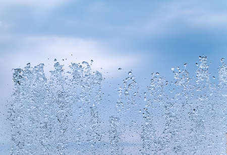 Splashes of water against the blue sky background. Fountain, a jet of water against the blue sky.の写真素材