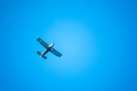 Retro green biplane plane in the blue sky. Old airplane against blue skyの写真素材