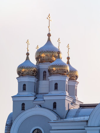 The golden domes of the Christian church are covered with snow in winter. Orthodox temple with...