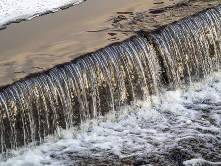 A small flat cascade in a calm river. Water backgroundの写真素材