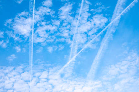 Blue sky with airplane trails and clouds. Blue sky with many clouds lines made of aircraftの写真素材