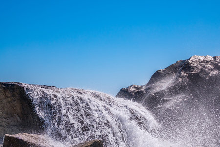 Sea water beats against rocks. Sea waves of dark water beat against the coastal rocks. An infinite...