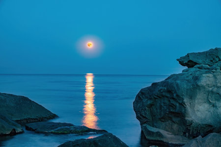 Super full blood moon and moon light over the sea. Full red moon with reflection in water with...