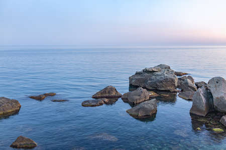 Twilght over the wild rocky beach coastline and the sea. Sea and rocks at night wide angle view. Panoramic landscape in Crimea, Nora, near Alupka town.の写真素材