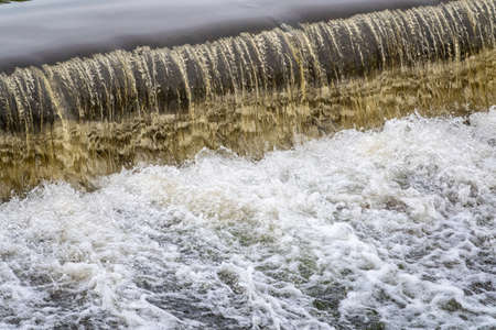 A small flat cascade in a calm river. Water backgroundの写真素材
