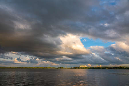 Lake with pine and birch forest on the shores at summer or early autumn sunset. The sky is reflected in the waterの写真素材