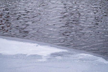 The surface of the water is partially covered with ice. Dangerous Thin Ice. Cold winter weatherの写真素材
