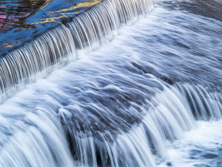 A small flat cascade in a calm river. Water backgroundの写真素材