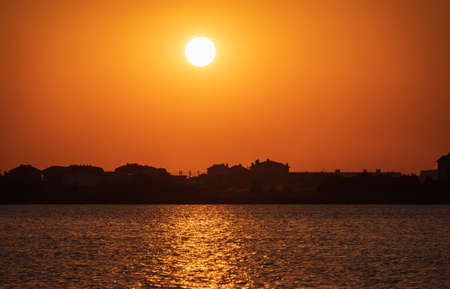 The sun goes down over a lake. Dramatic Sunset Skyの写真素材
