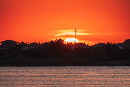 The sun goes down over a lake. Dramatic Sunset Skyの写真素材
