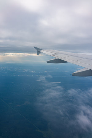 View from the airplane window at a beautiful blue sunrise and the airplane wing in clear sky. Earth and sky as seen through window of an airplane.の写真素材