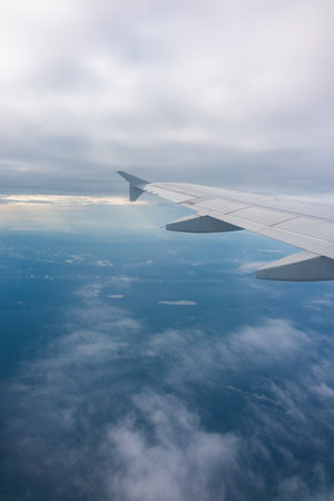 View from the airplane window at a beautiful blue sunrise and the airplane wing in clear sky. Earth and sky as seen through window of an airplane.の写真素材