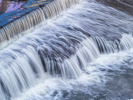 A small flat cascade in a calm river. Water backgroundの写真素材