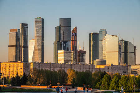 Moscow, Russia - May, 10, 2021: Green trees on background modern skyscrapers in the Moscow city. Panorama of new Moscow City buildings in springのeditorial素材
