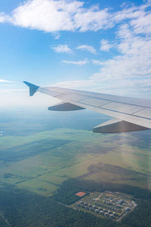 View from the airplane window at a beautiful blue sunrise and the airplane wing in clear sky. Earth and sky as seen through window of an airplane.の写真素材