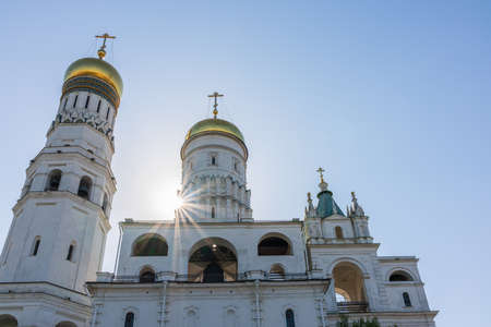 Ivan the Great Bell Tower, with Assumption Belfry on the right on a sunny day with blue sky. Blue sky background with sunbeams. Moscow Kremlin, Russiaの写真素材