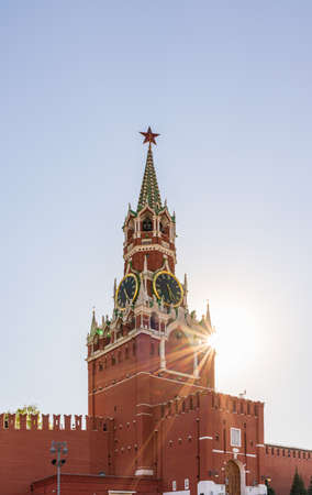 Spasskaya Tower of Moscow Kremlin. The Spasskaya Tower is the main tower with a through-passage on the eastern wall of the Moscow Kremlin, which overlooks Red Square. Blue sky background with sunbeamsの写真素材