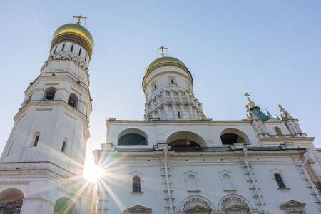 Ivan the Great Bell Tower, with Assumption Belfry on the right on a sunny day with blue sky. Blue sky background with sunbeams. Moscow Kremlin, Russiaの写真素材