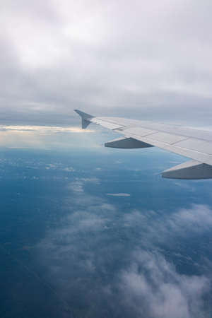 View from the airplane window at a beautiful blue sunrise and the airplane wing in clear sky. Earth and sky as seen through window of an airplane.の写真素材