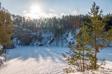 Sheer cliffs and rocks around the Talc quarry in winter in Russia in the town of Sysert, near Yekaterinburg. Pine and birch on a snow-covered rockの写真素材