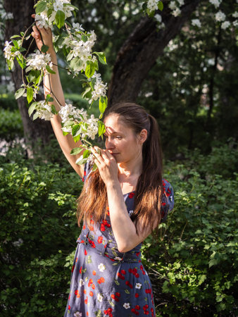 Beautiful Young woman without makeup in a spring park flowering among trees. Close-up portrait of a...
