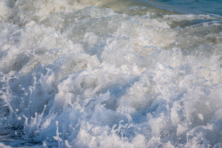 Splashes of water and foam against the sea on a sunny summer day. copy space background
