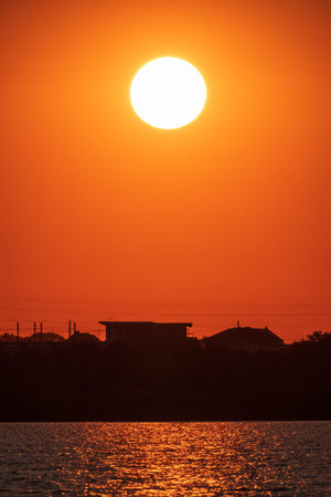 The sun goes down over a lake. Dramatic Sunset Skyの写真素材
