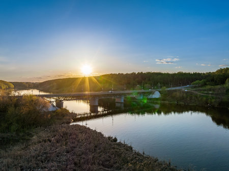 Beautiful view of the bridge across the Iset river in the city of Kamensk-Uralsky at sunset in...