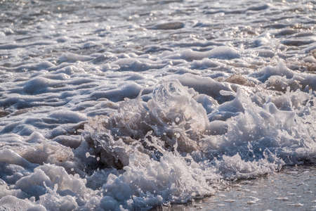 Splashes of water and foam against the sea on a sunny summer day. copy space backgroundの写真素材