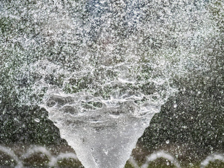 Water splashes from fountain on dark background. Natural texture of only water of fountain. High...