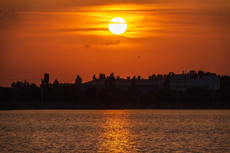 The sun goes down over a lake. Dramatic Sunset Skyの写真素材