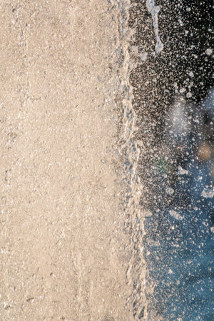 Splashes of water against light background. Fountain, a jet of water against cloudy sky.の写真素材