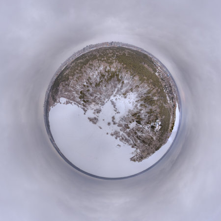 Snow-covered forest on lake shore with ice at sunset, aerial view. Beautiful winter forest landscape. picturesque northern nature. little planet sphere modeの写真素材