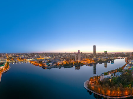 Yekaterinburg city and pond aerial panoramic view at summer or early autumn night. Night city in the early autumn. Buildings of Iset Tower, Yeltsin Center. Yekaterinburg, Russia. aerial view.の写真素材