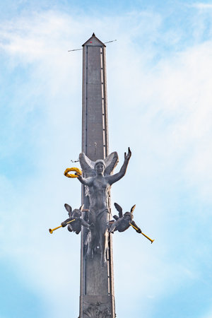 Moscow, Russia - July 31, 2022: Bronze statue of the goddess of Victory Nike and figures of angels on top of Victory Obelisk at Poklonnaya Hill,Victory Park against blue sky. Author Zurab Tsereteliのeditorial素材