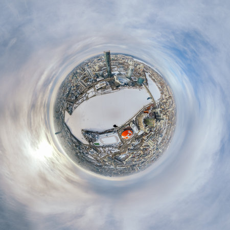 Aerial winter city view with crossroads and roads, houses, buildings, parks and bridges. Copter...