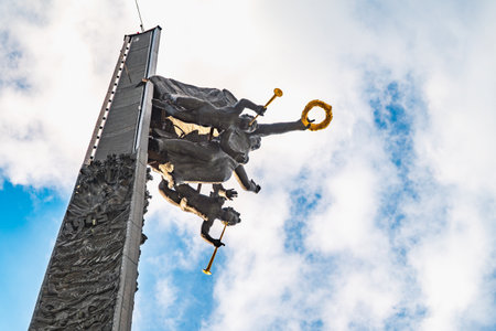 Moscow, Russia - July 31, 2022: Bronze statue of the goddess of Victory Nike and figures of angels on top of Victory Obelisk at Poklonnaya Hill,Victory Park against blue sky. Author Zurab Tsereteliのeditorial素材