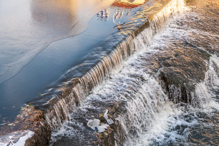A small flat cascade in a calm river. Water background
