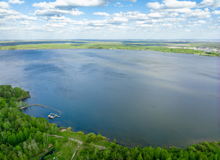 Big lake with green shores in bright sun light, aerial landscape. Recreation concept. Sky reflection. Ecology in Europe. Aerial viewの写真素材