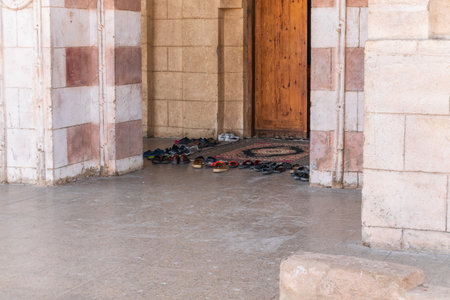 Believers' shoes left in front of the entrance to the Muslim mosque. Footwear of prayers left in front of a mosqueの写真素材