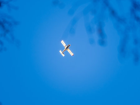 Small ultralight airplane with overhead wing and single propeller flying in sunset sky. Such aircraft are used for recreational, sport and flight training.の写真素材
